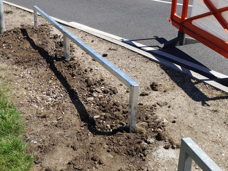 Metal knee rail installed to protect grass verge from vehicles