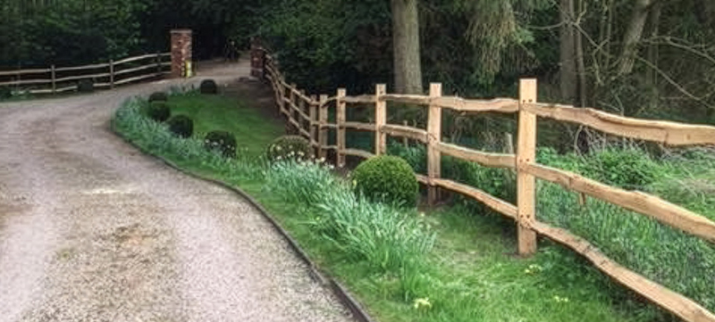 Cleft chestnut post and rail fence at front of period property