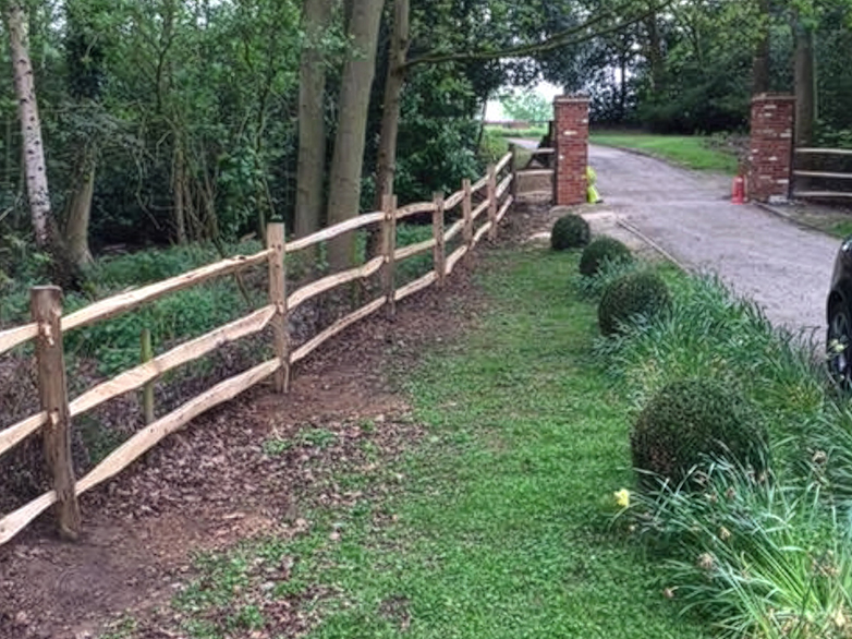 Cleft chestnut fence running alongside a driveway at a period property