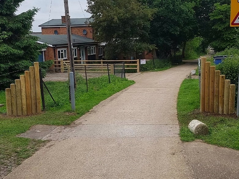 Round posts driven into ground with back rail for demarcation