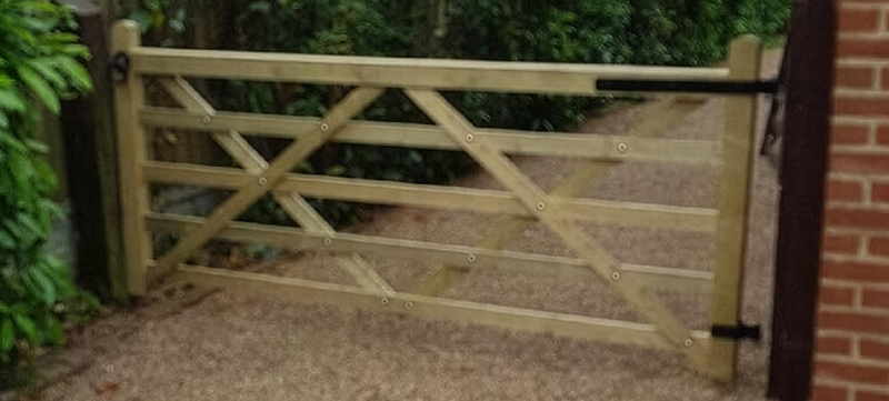 Timber field gate with black ironmongery installed at driveway