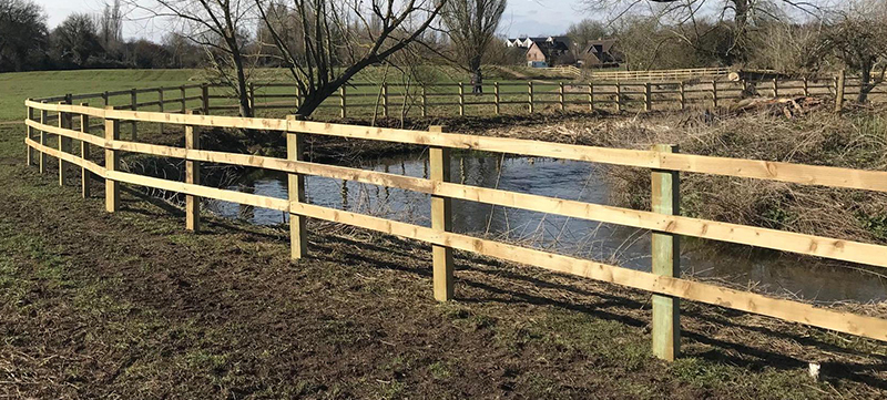 UC4 post and rail fencing along riverbank in Harpenden