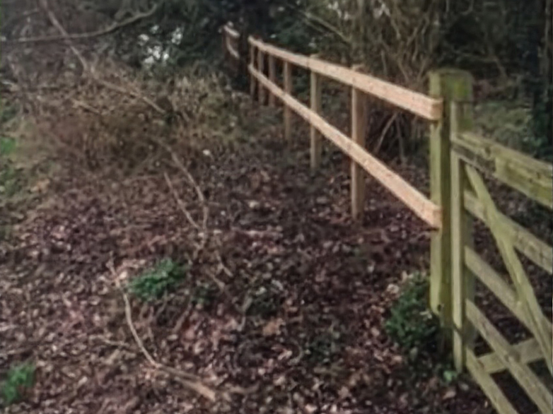 Churchyard fence with wooden post and rail fencing