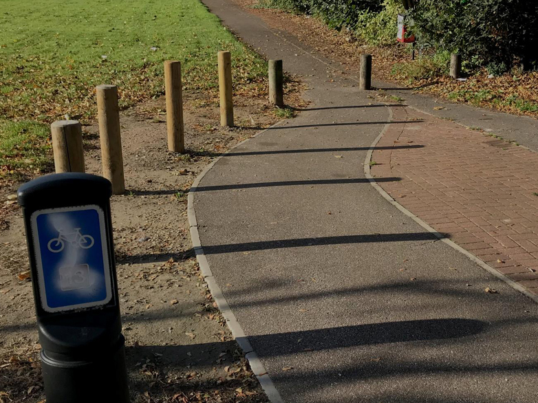 Newly installed heavy-duty bollards lining a cycle path