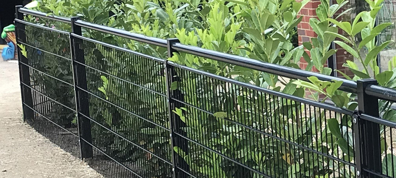 Gloss black spectator rail fencing around office park