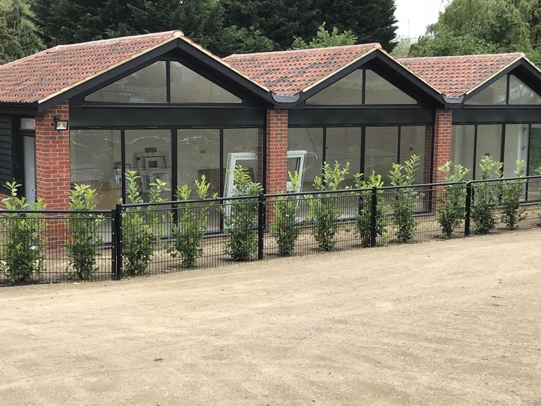Spectator rail fencing surrounding parkland with office buildings