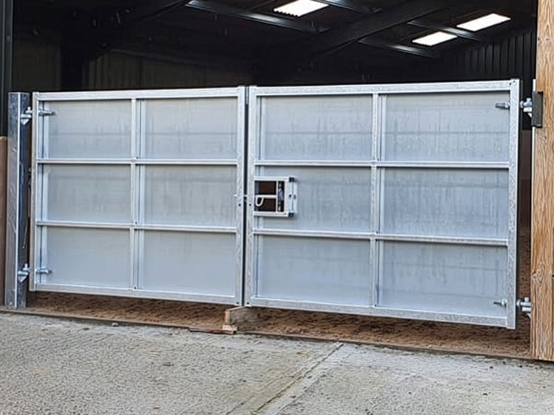 Sheeted gates reducing draught at riding school entrance
