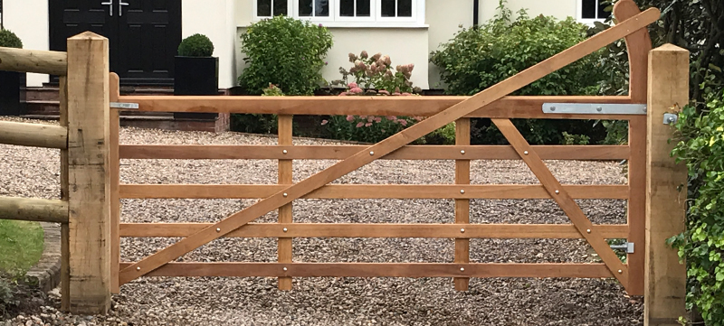 Iroko hardwood entrance gates on oak posts at country property